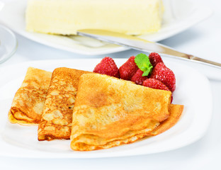 Traditional Russian pancakes with black tea and strawberries.