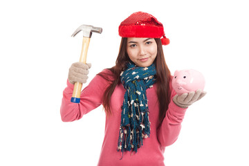 Asian girl with red christmas hat ,hammer and piggy bank