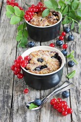Cake with seasonal berries and crumble of oatmeal and almonds