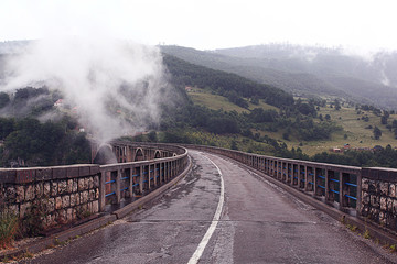 Obraz na płótnie Canvas bridge in the mountains fog clouds rain