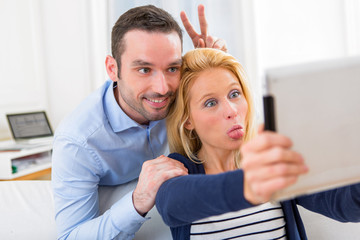 Fototapeta premium Young attractive couple having fun doing selfie