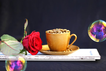 goldfarbene Tasse mit roter Rose