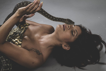 Model, Sensual tattooed woman with big snake and iron corset