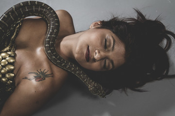 Sexy warrior tattooed woman with big snake and iron corset