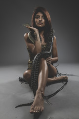 Sensual tattooed woman with big snake and iron corset