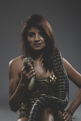 Sexy warrior tattooed woman with big snake and iron corset