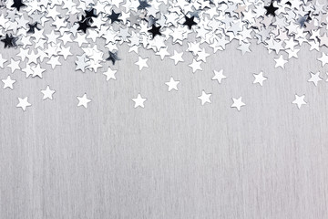 Star confetti on silver metal background