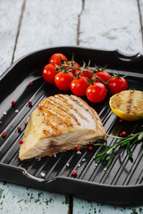 Grilled fish fillet with lemon and cherry tomatoes