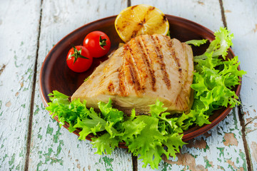 Grilled fish fillet with lemon and cherry tomatoes