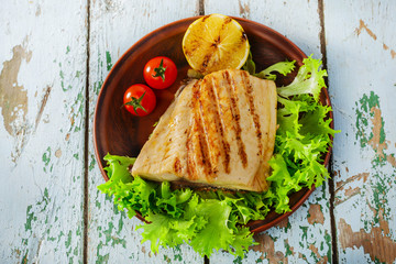 Grilled fish fillet with lemon and cherry tomatoes