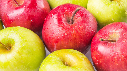 Red and green apple over white background