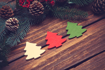 Three christmas tree toys on wooden table.