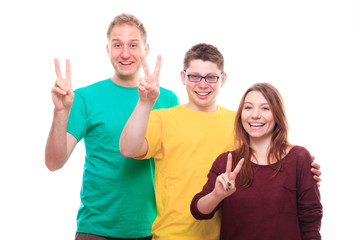 Three young people showing victory sign and smiling