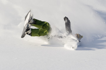 Snowboarder falls on fresh snow
