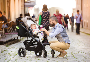 Hipster business man with baby in pram in town