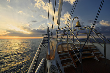 Naklejka premium Yacht Sailing against sunset. Sailboat. Sailing