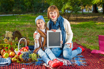 Happy mother with little daughter in autumn park