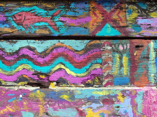 Graffiti art of fish and ethnic patterns on a wooden surface in pink and bright blue colors