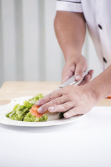 Chef's hands cutting Tomato