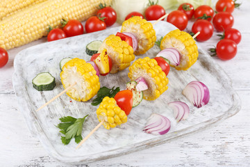 Sliced vegetables on picks on board on table close-up