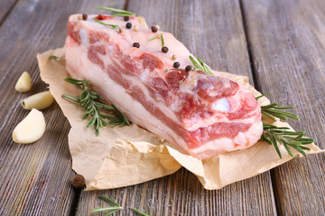 raw bacon with spices on wooden table