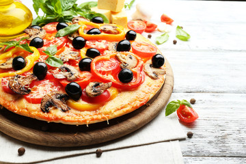 Delicious pizza served on wooden table