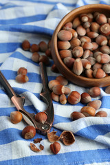 Hazelnuts in wooden bowl, on napkin background