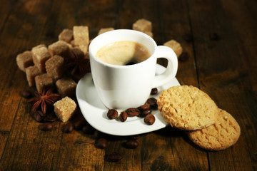 Cup of espresso and tasty cookie on wooden background
