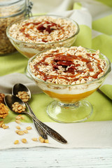 Tasty dessert with oat flakes and honey, on table