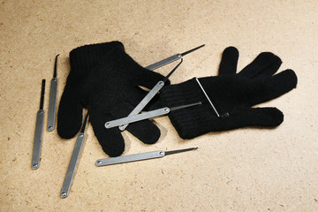 Lock picks with gloves on wooden table
