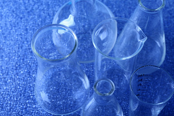 Different laboratory glassware on color background