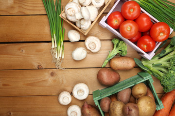 Different vegetables in boxes on wooden background top view