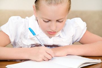 Schoolgirl child writes in a notebook