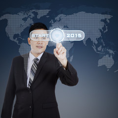 Man pressing a button to start business in 2015
