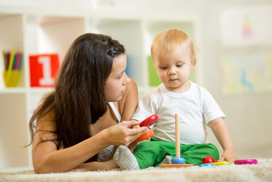 cute mother and baby boy play together indoor at home