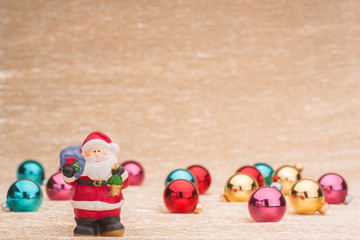 Santa Claus with Сhristmas balls on illuminated background