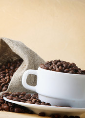 A sack of coffee beans and a cup, closeup