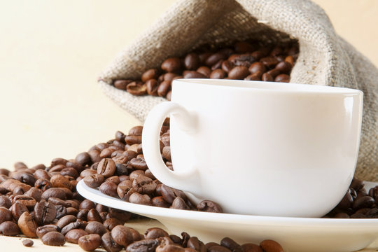 A sack of coffee beans and a cup, closeup