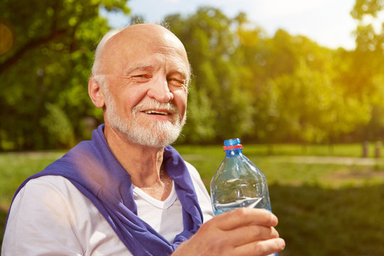 Durstiger Senior trinkt Wasser im Sommer