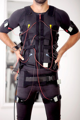 fit man on  electro muscular stimulation machine - obrazy, fototapety, plakaty