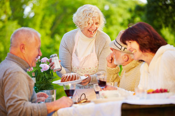 Gruppe Senioren beim Kuchen essen im Garten