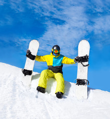 Fototapeta na wymiar snowboarder hold two snowboards sitting on snow