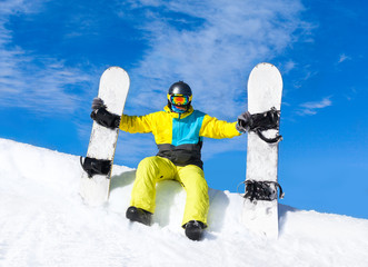 Fototapeta na wymiar Snowboarder sitting snow slope snowboards