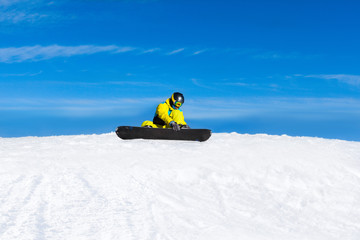 snowboarder sitting on snow mountain slope