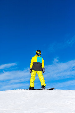 Snowboarder sliding down the hill, snow mountains