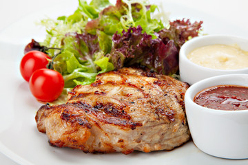 Barbecue grilled steak meat with vegetables and sauses.