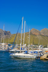 Fototapeta na wymiar Yacht in harbor and mountains of Port de Pollenca, Mallorca