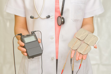 Doctor's hold Medical Tens Unit for pain therapy
