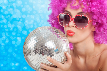 beautiful young girl with a pink wig holding a disco ball