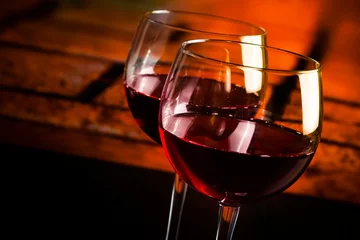 Fotobehang red wine glasses on wood table with warm atmosphere background © donfiore